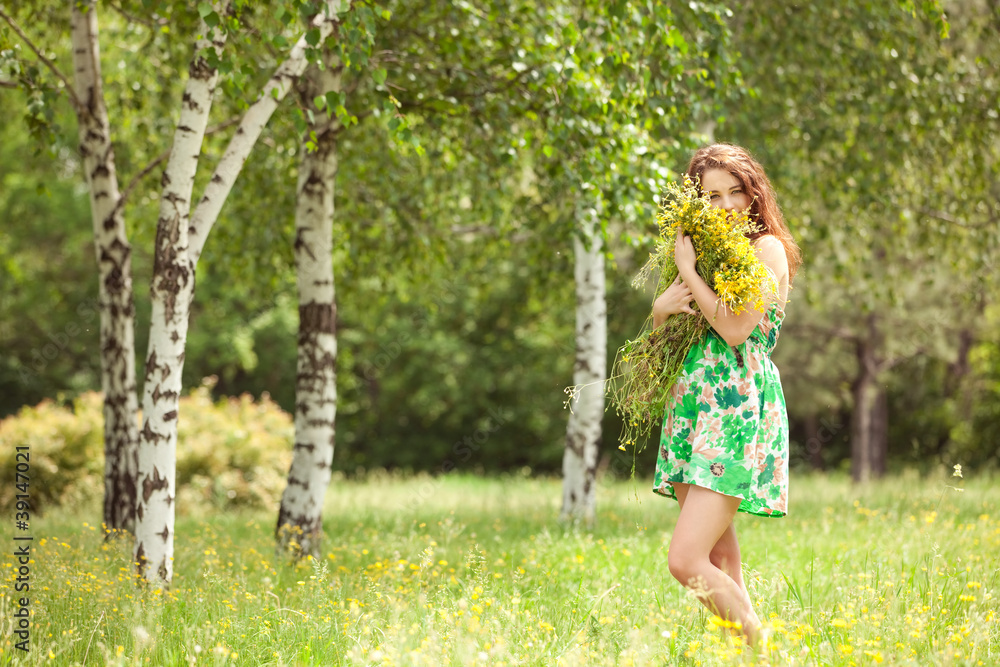 Young redhead woman in the park with flowers Young redhead woman in the park with flowers