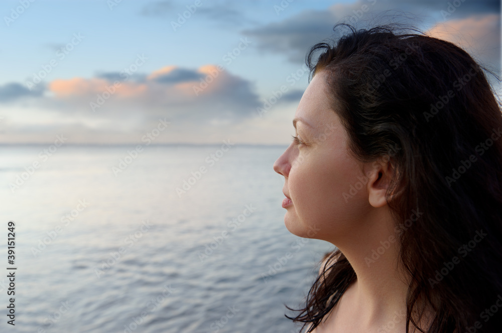 The attractive woman on seacoast and beautiful color sky The attractive woman on seacoast and beautiful color sky