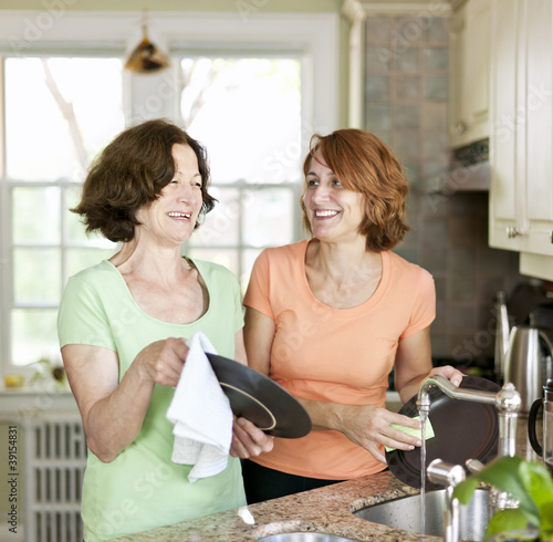 Fotografie Women doing dishes in kitchen