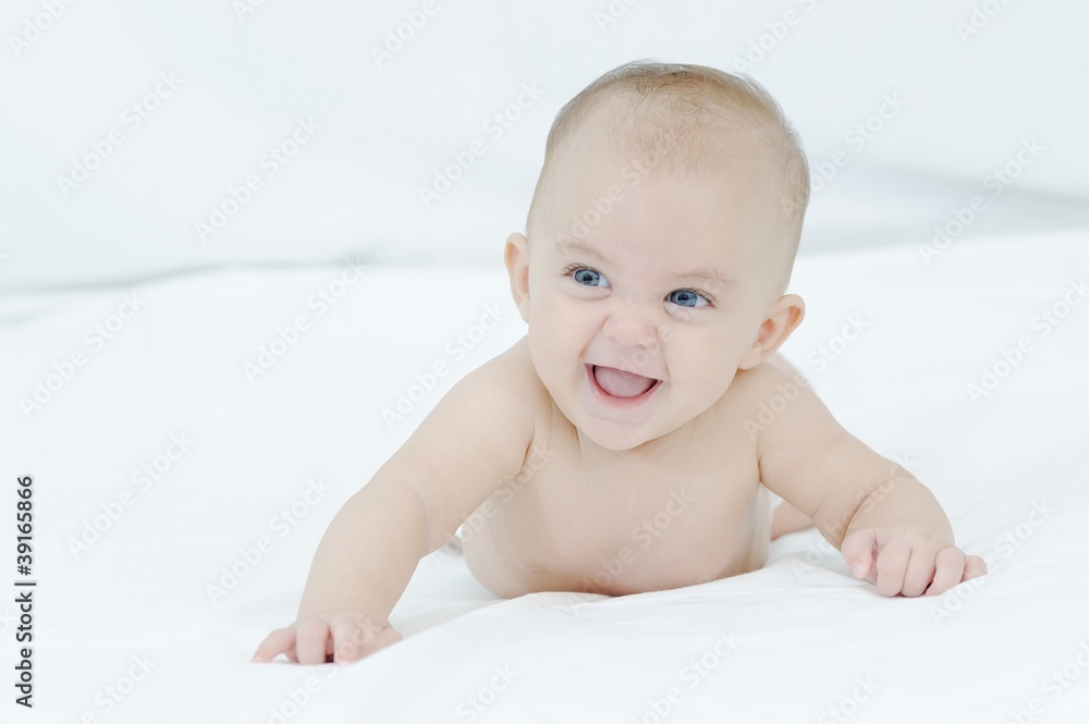 Happy smiling child playing on a white bed Happy smiling child playing on a white bed