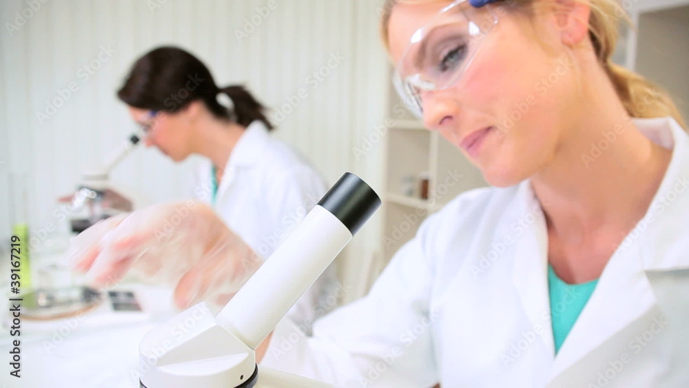 Female Medical Researchers Using Microscopes