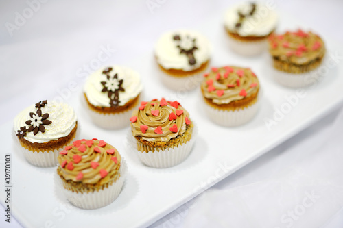Decorated colorful cupcakes on a white plate