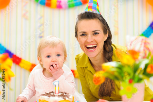 Portrait of mother with baby eating birthday cake