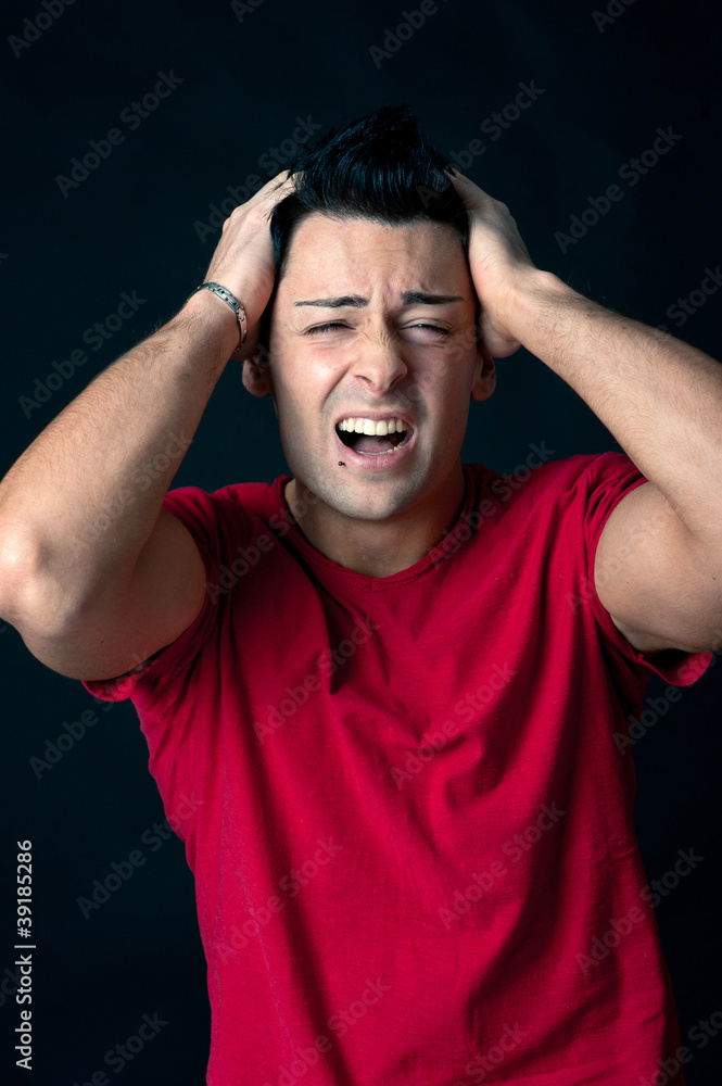 Man portrait with frustrated expression on dark background.