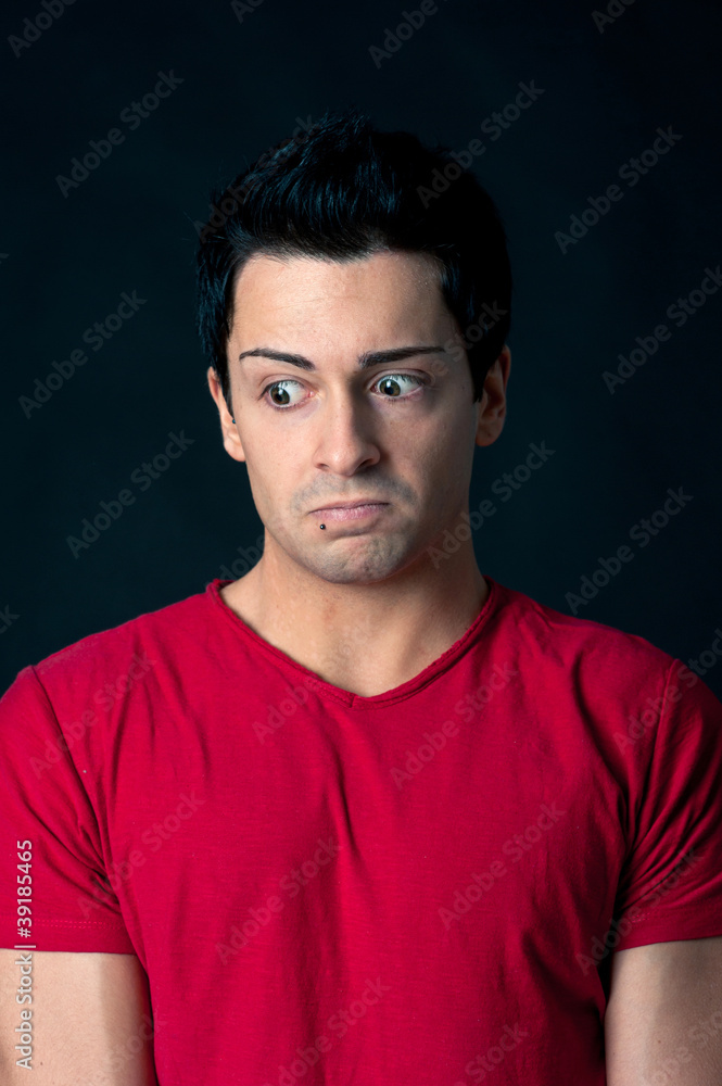 Man portrait with doubtful expression on dark background.