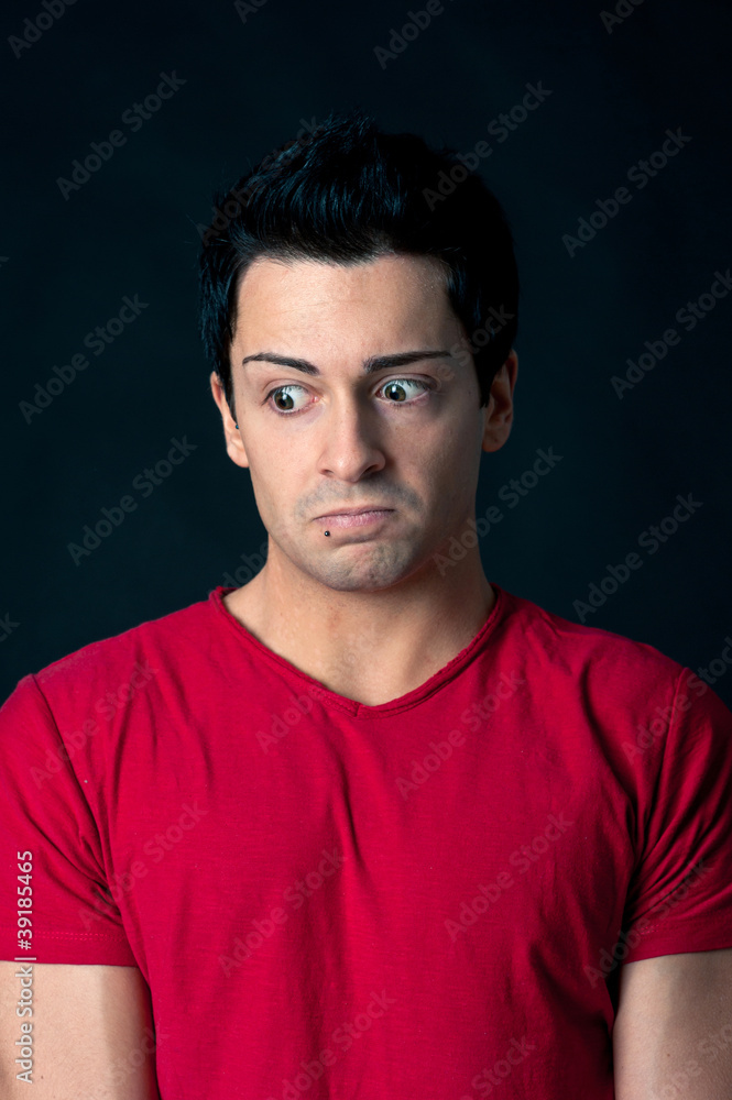 Obraz premium Man portrait with doubtful expression on dark background.
