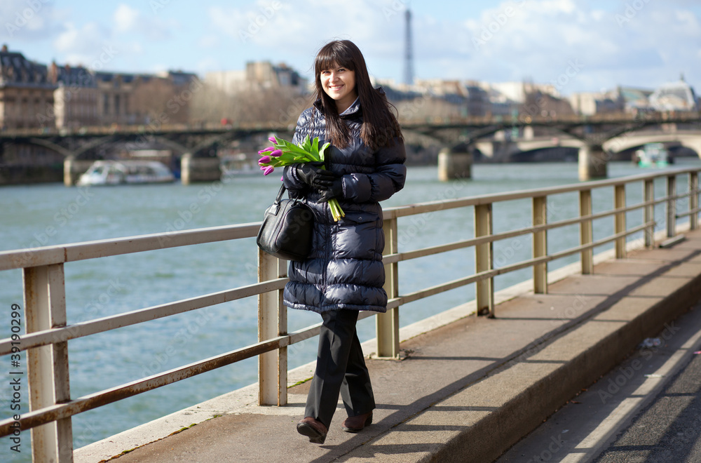 Obraz premium Happy beautiful girl with tulips enjoying spring day in Paris