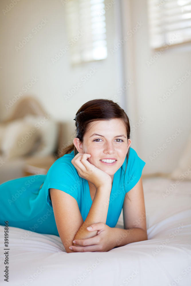happy teen girl lying on her bed at home happy teen girl lying on her bed at home