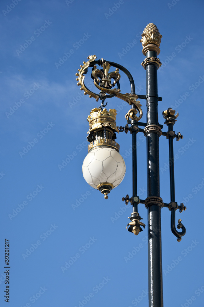 Old street lamp next to the Royal Palace of Madrid, Spain