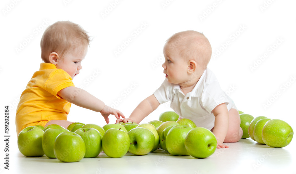 Two little children with green apples isolated on white backgrou Two little children with green apples isolated on white backgrou