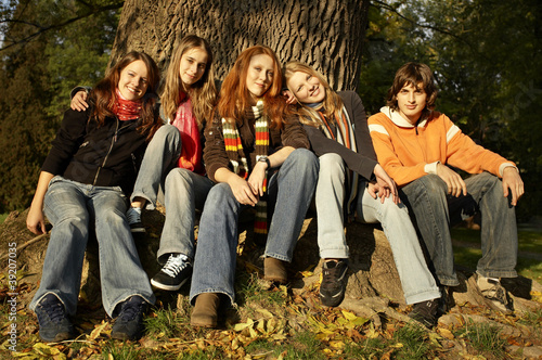 Group of friends sitting by the tree