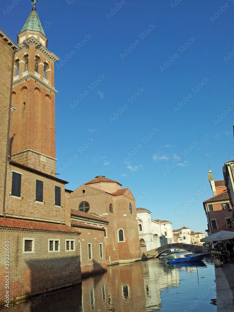 reflections of the medieval church in the Canal in Chioggia