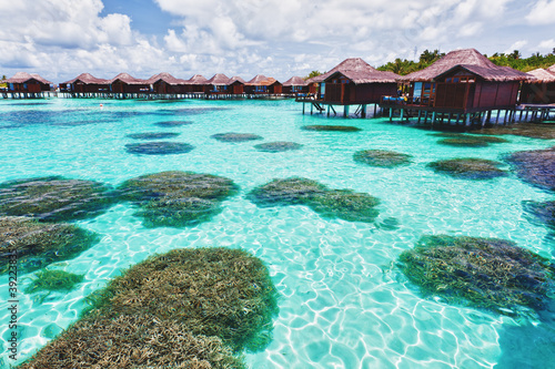 Over water bungalows and lagoon with coral