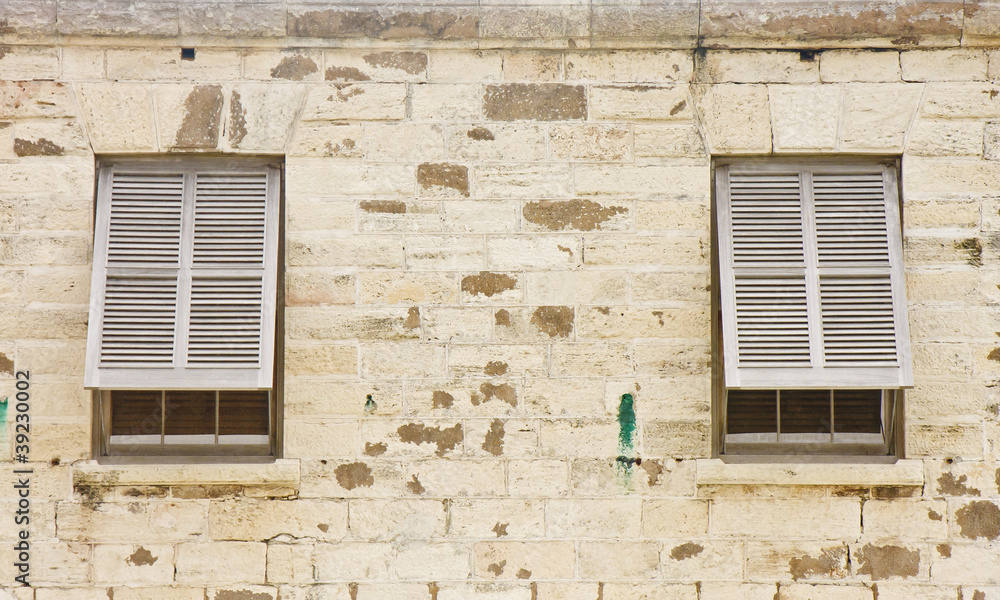 Two Wood Shutters in an Old Stone Block Wall