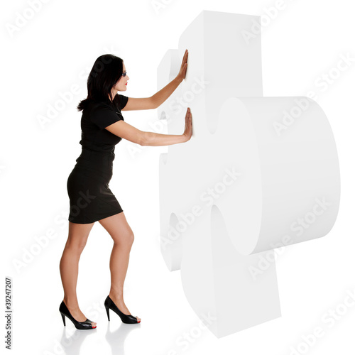 Businesswoman pushing gient puzzle photo