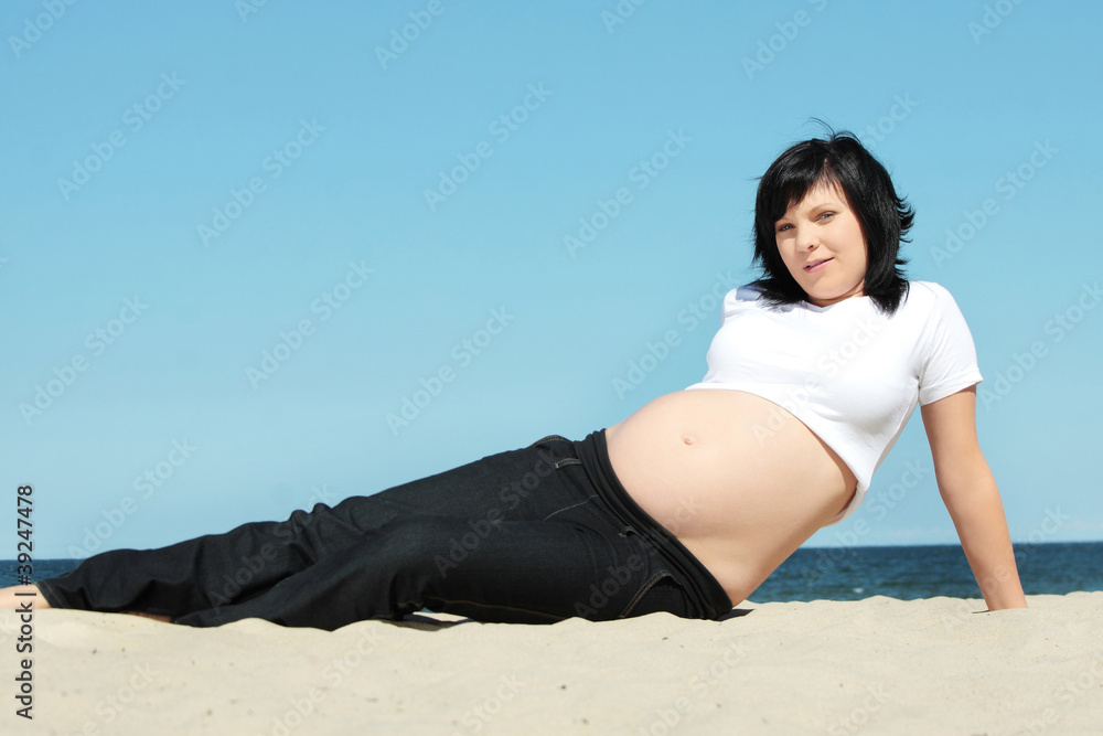 Pregnant woman relaxing at the beach