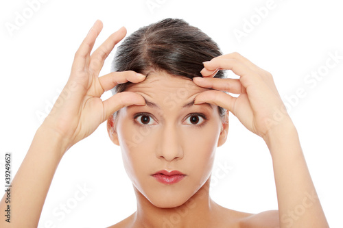 Woman checking her wrinkles on her forehead