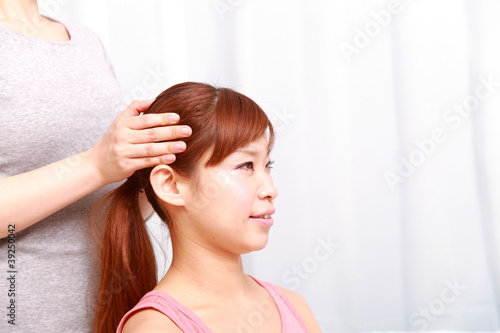 young japanese woman getting a head massage
