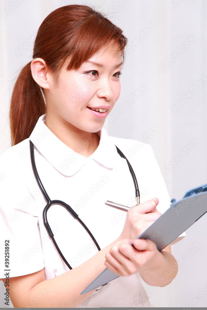 young japanese nurse with medical chart smiles young japanese nurse with medical chart smiles