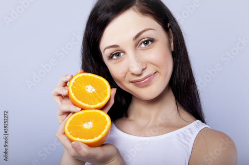 Young happy girl with orange in her hands