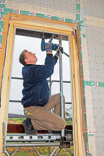 carpenter mounting a new window photo