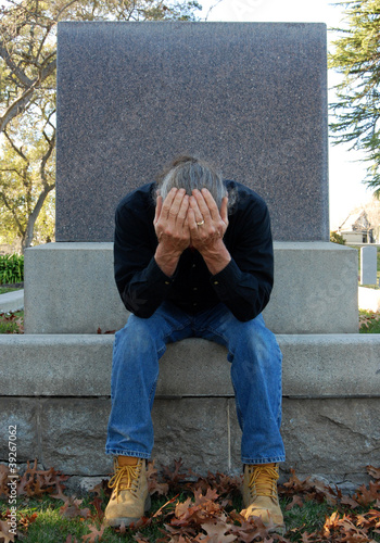 Man sitting at gravesite