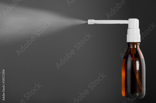 Bottle of throat spray isolated on gray background photo