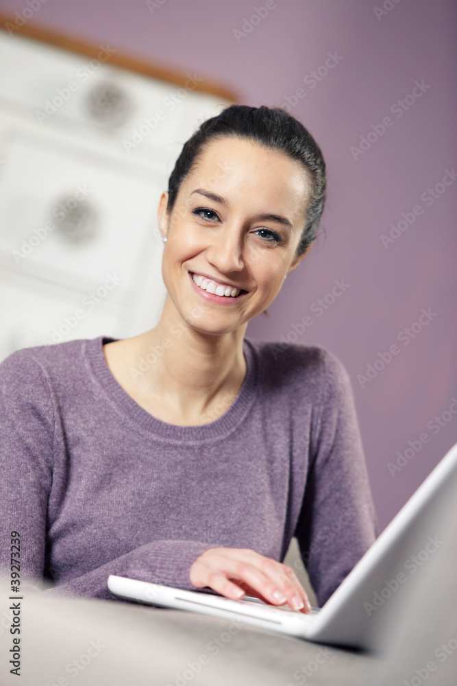Fototapeta premium portrait of young woman on the sofa using laptop