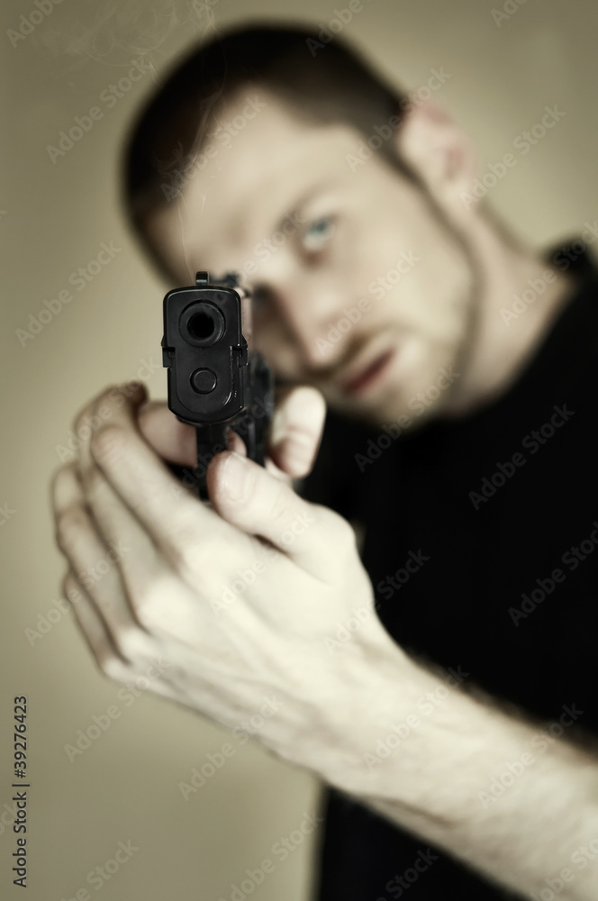 Desaturated image of a man pointing a gun at you Desaturated image of a man pointing a gun at you