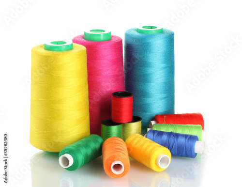 Many-coloured bobbins of thread isolated on white