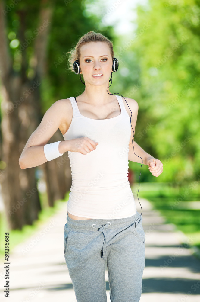 Young woman running in green park Young woman running in green park