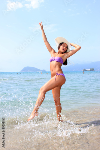 Bikini young girl is jumping up in the air
