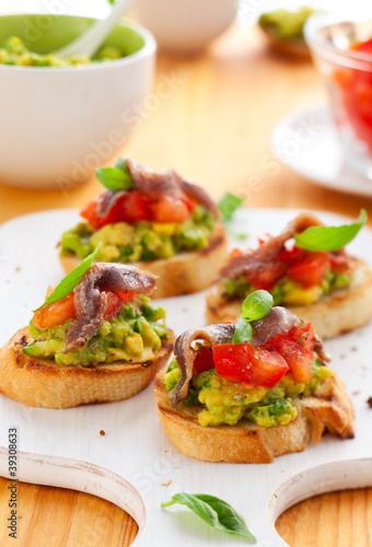 crostini with avocado tomato and anchovy