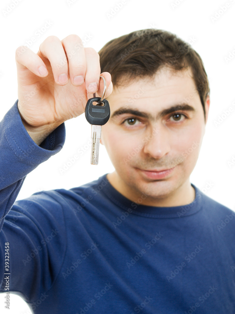 Fototapeta premium Young man holding keys in his hand, white background