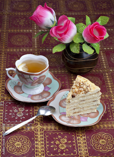 Breakfast in a retro style. Cake, tea with lemon and a bouquet