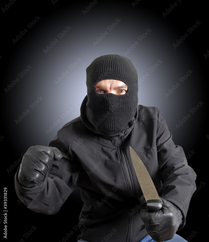Masked criminal holding a knife