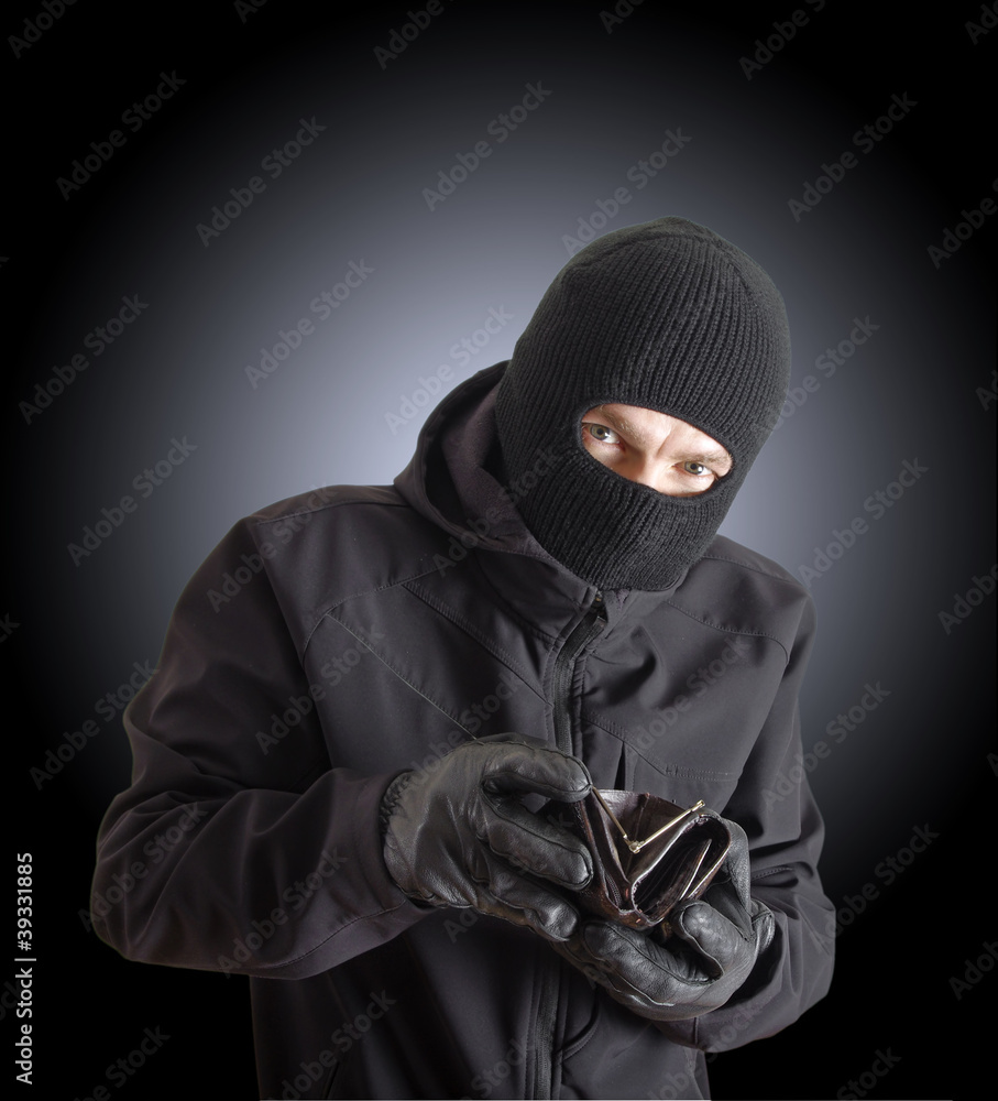 Masked criminal holding a stolen leather purse Masked criminal holding a stolen leather purse
