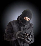 Masked criminal holding a stolen leather purse