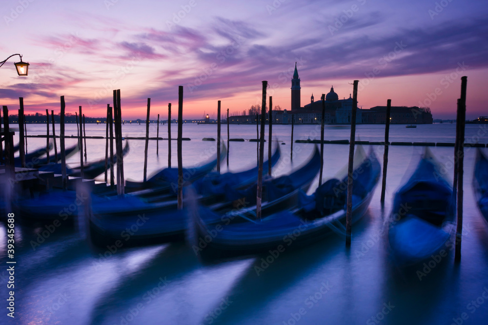 Gondolas moored by Saint Mark's square at dawn in Venice