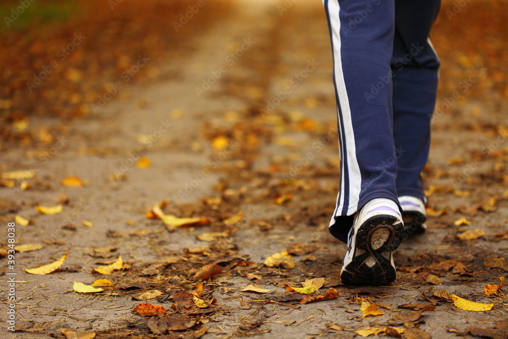Woman walking cross country trail in autumn forest Woman walking cross country trail in autumn forest