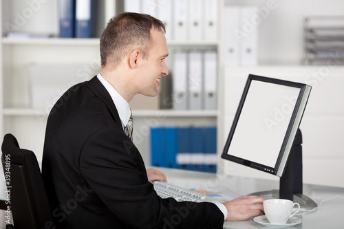 geschäftsmann im büro schaut auf seinen bildschirm