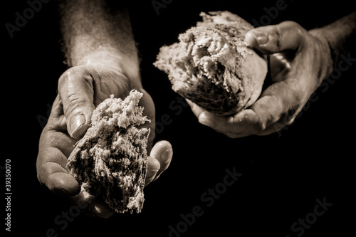 Human Hand giving a piece of bread photo