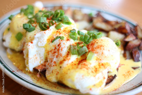 Foto Eggs benedict with salmon and grilled potatoes.