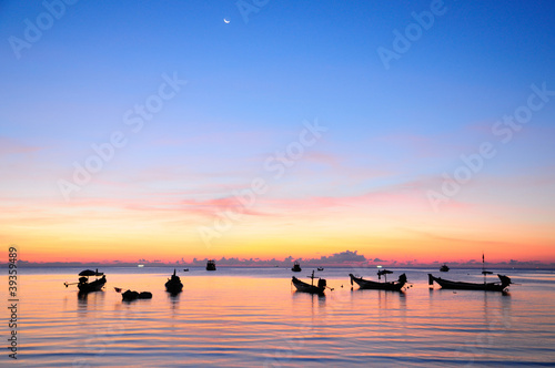 Golden sunset on a sea with silhouette of ships at Suratthani