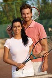 Smiling couple on tennis court
