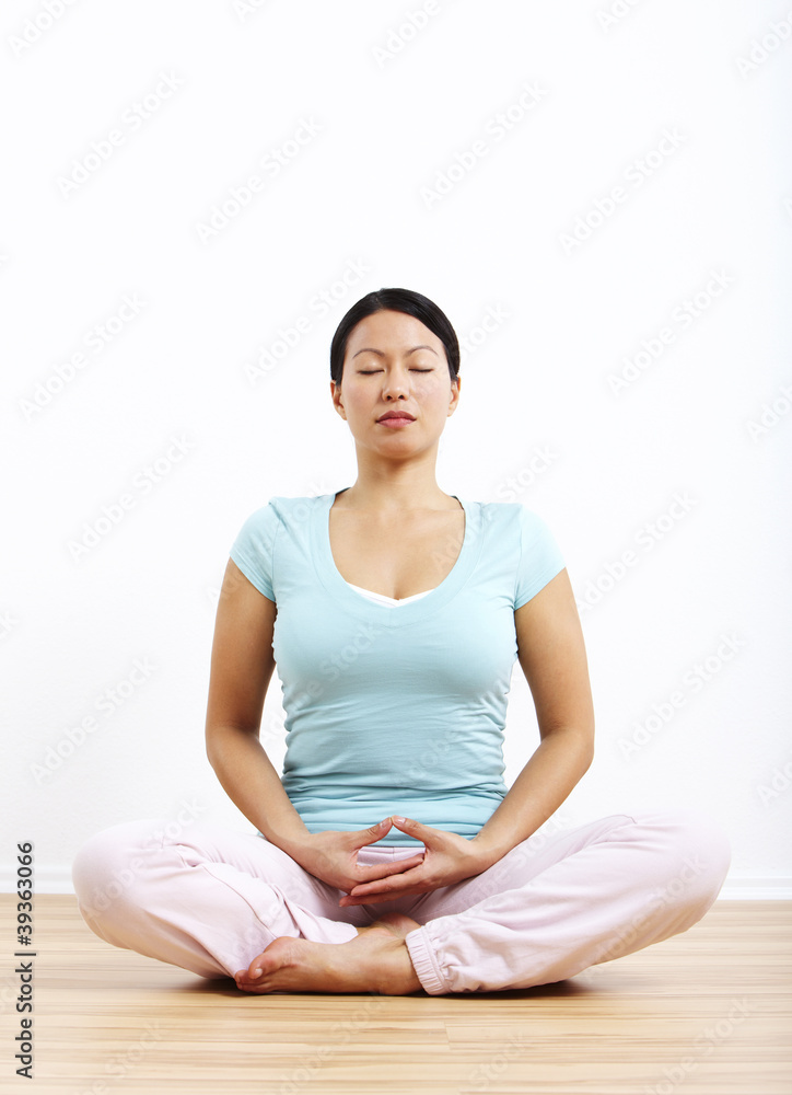 Frau in Meditationshaltung, Hände auf dem Schoß Frau in Meditationshaltung, Hände auf dem Schoß