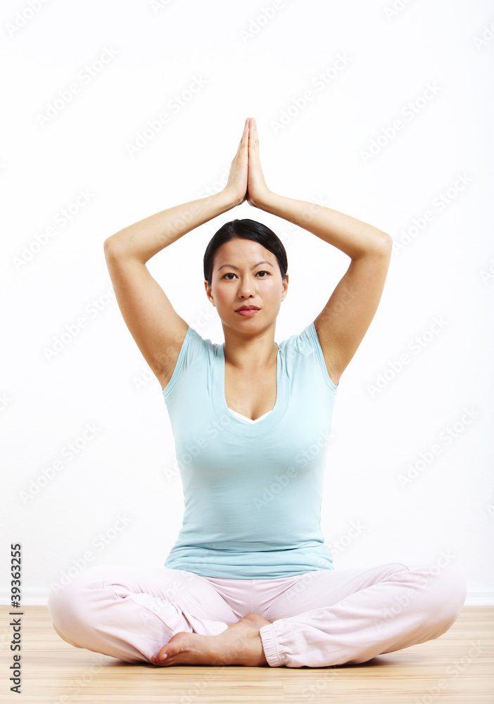 Frau in Meditationshaltung, Hände über dem Kopf