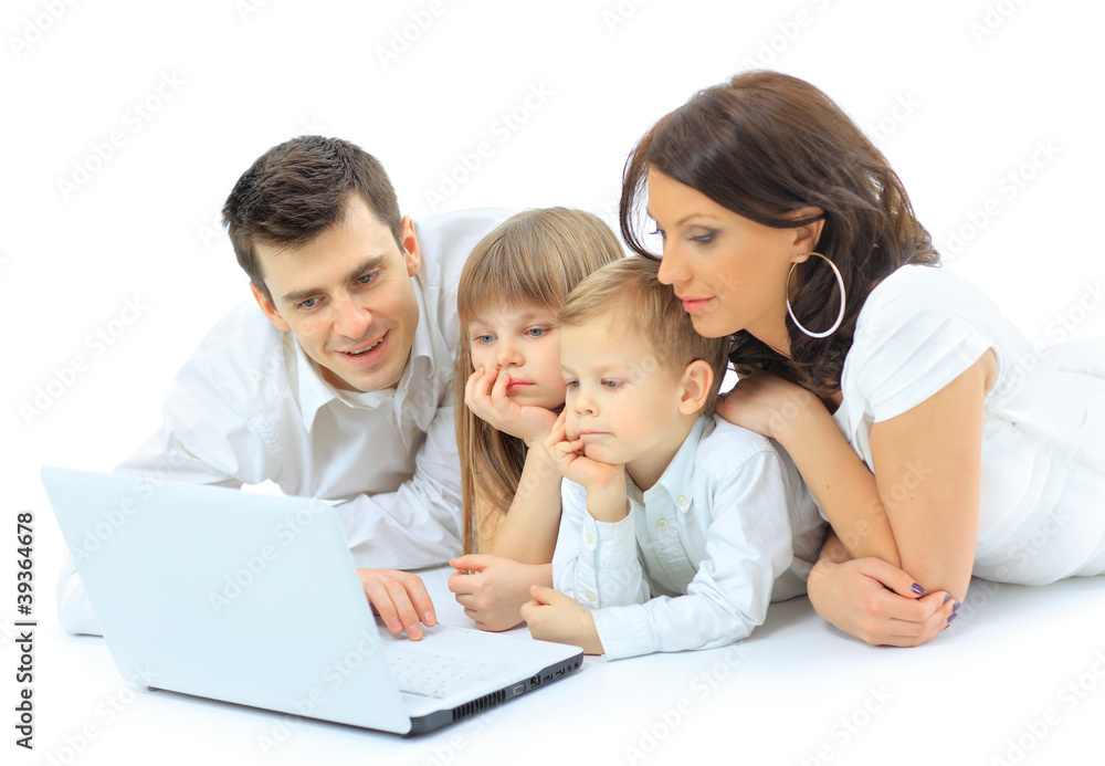 Loving family looking at a laptop lying down on bed