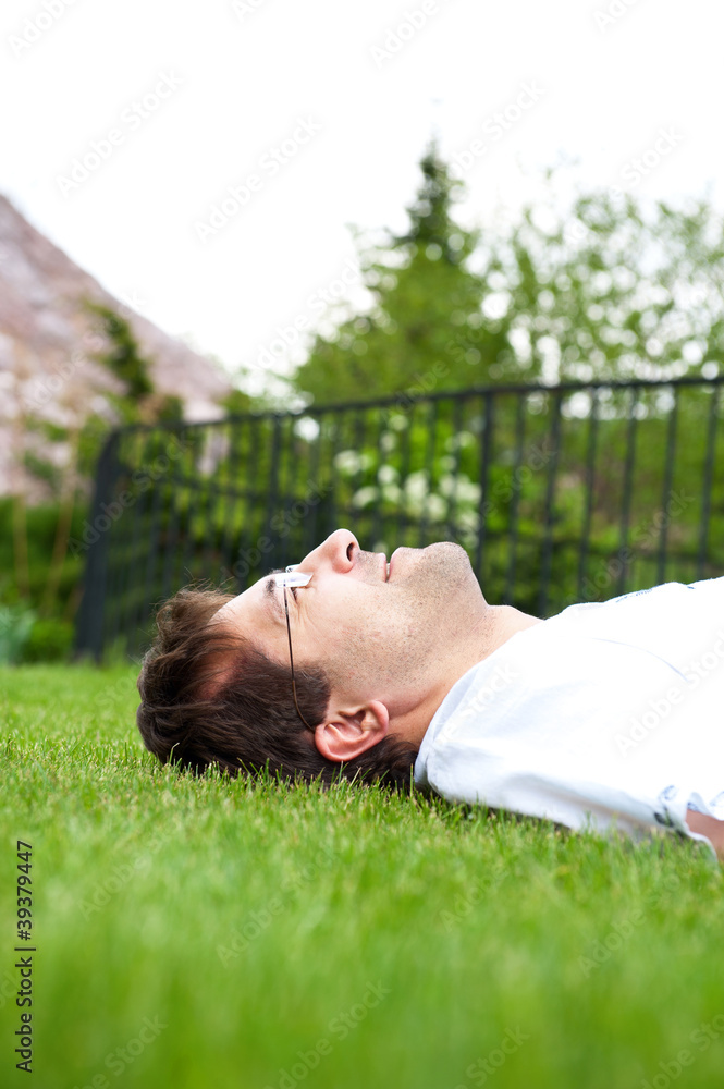 Good looking man lying on lawn and daydreaming Good looking man lying on lawn and daydreaming