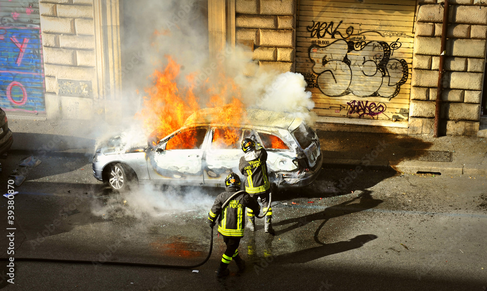 Fototapeta premium Riots - Fire fighters respond to a car fire